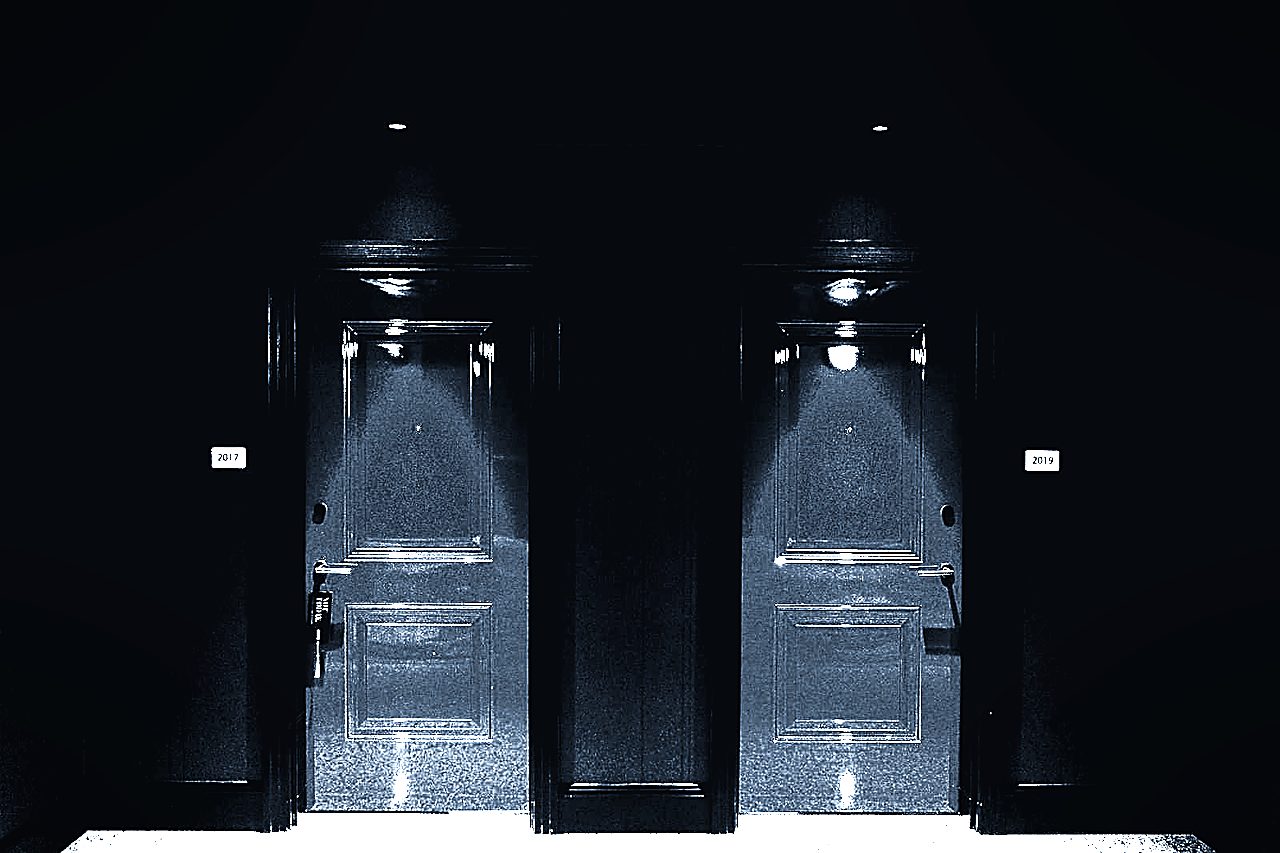 Illuminated doors in a dark hotel hallway with access control